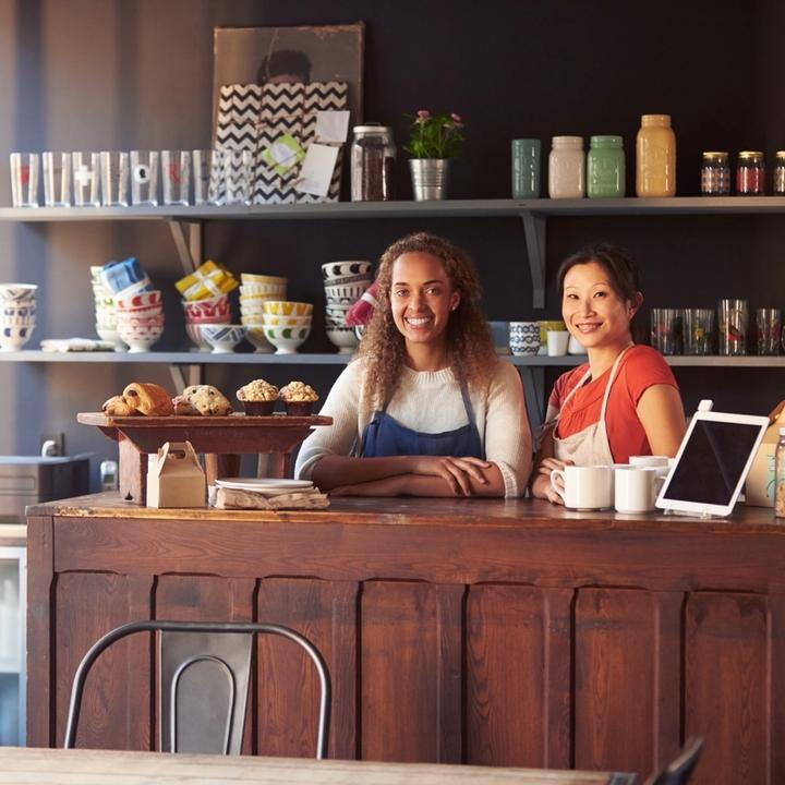 Two smiling retail workers at a small business